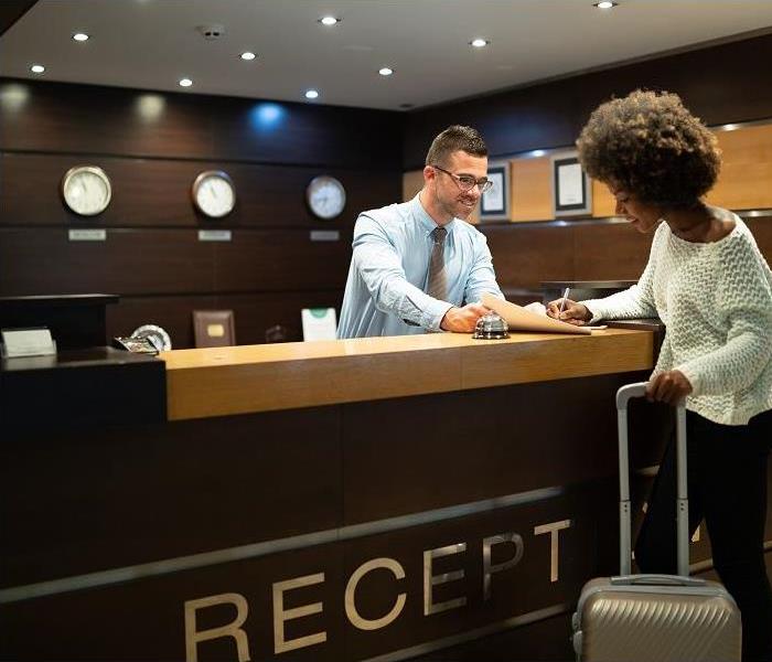 Hotel clerk helping woman check into hotel