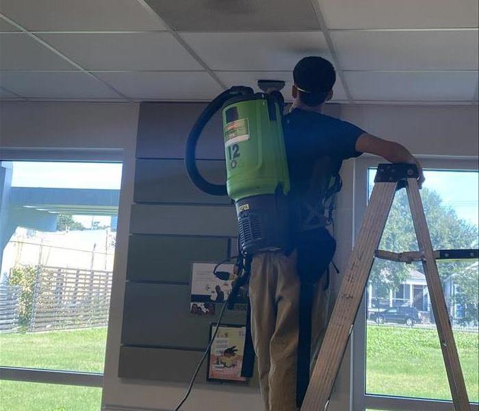 SERVPRO crew members cleaning ceiling tiles in a commercial building